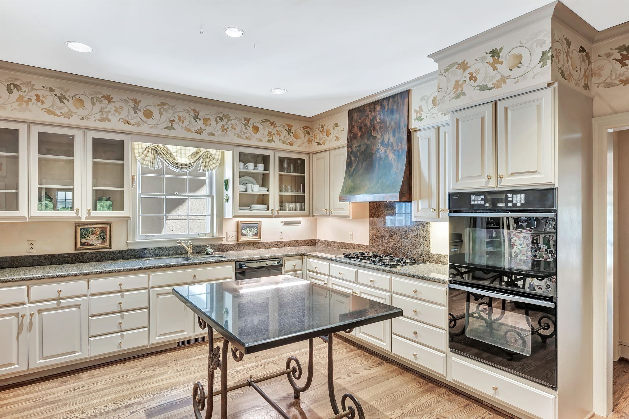 Kitchen with stone counters, double wall ovens and a center table at 102 Bellebrook Circle in Belle Meade Nashville
