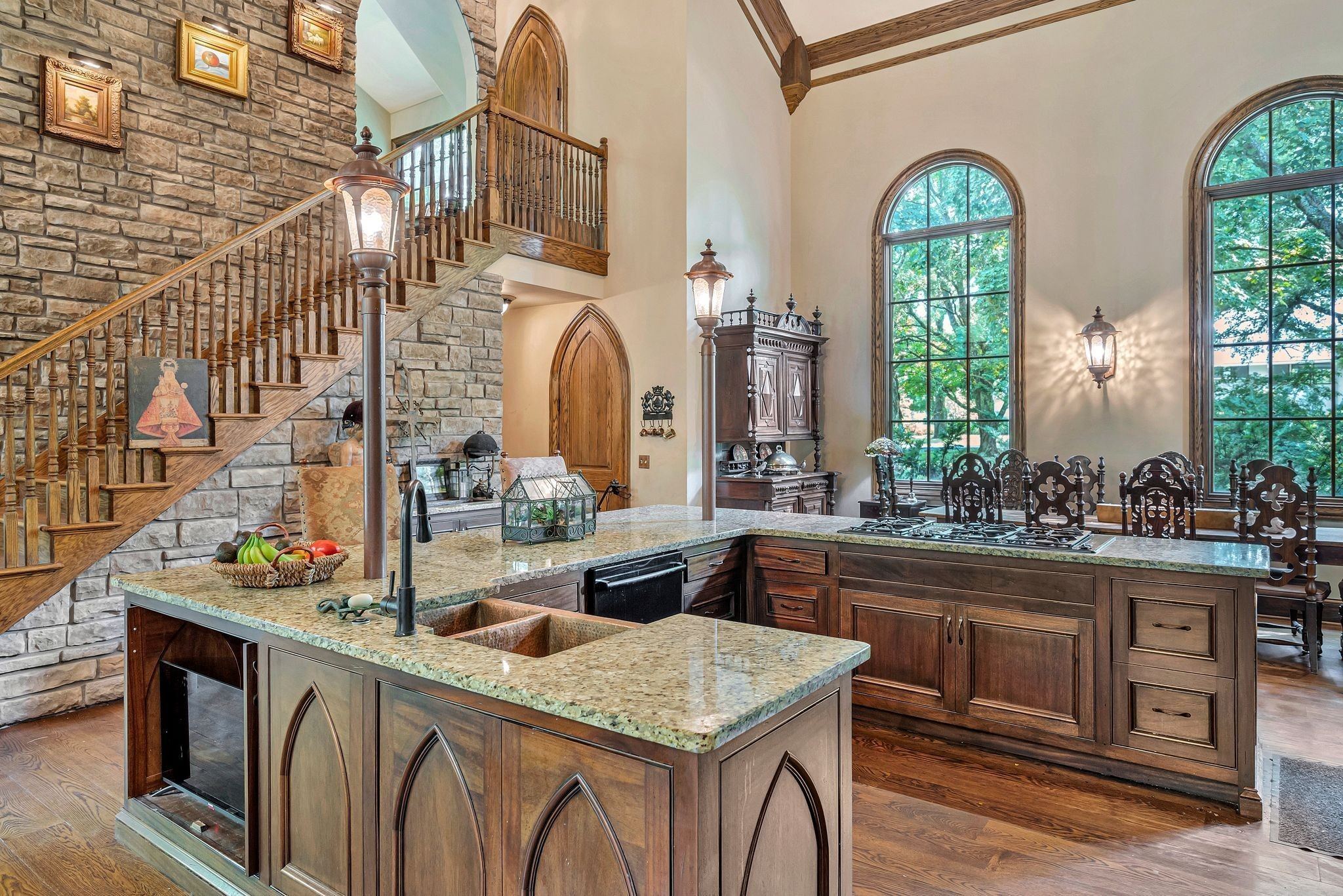 Kitchen with arched windows, stone counters and wood cabinetry at 1108 Belle Meade Boulevard in Belle Meade Nashville