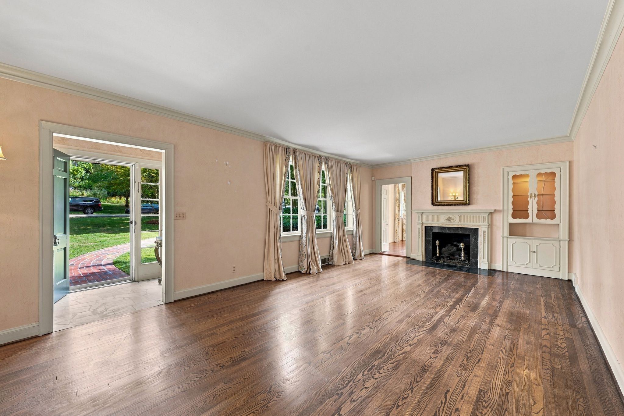 Living room with a fireplace, hardwood floors and tall windows at 317 Sutherland Avenue in Belle Meade Nashville