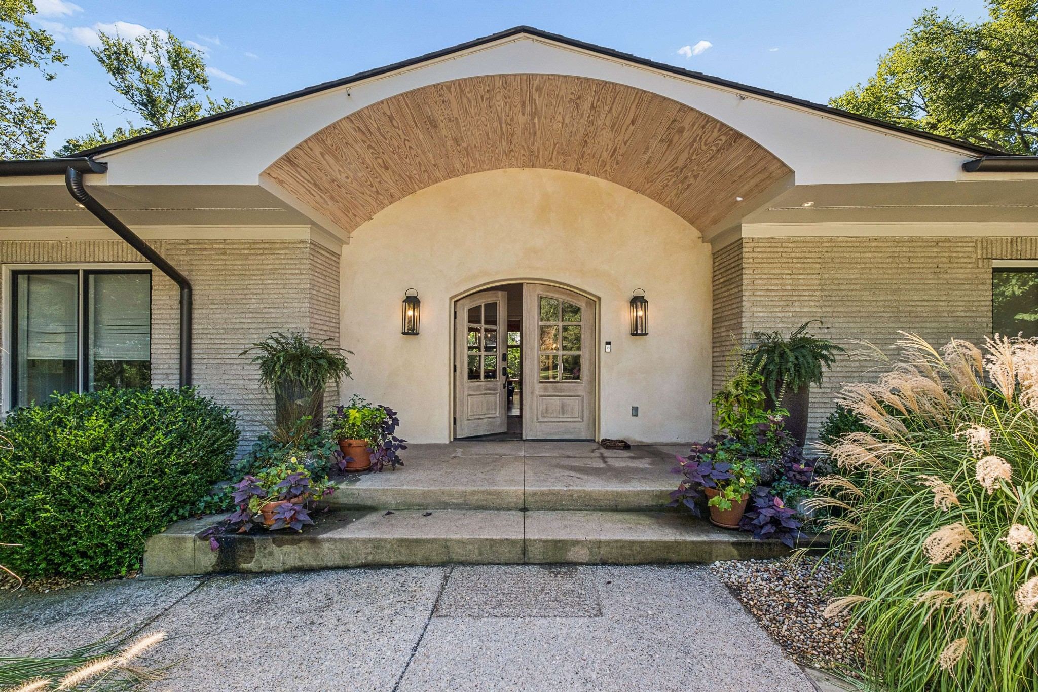 Arched front entry with double doors and a stone walk at 4301 Lillywood Road in Belle Meade Nashville