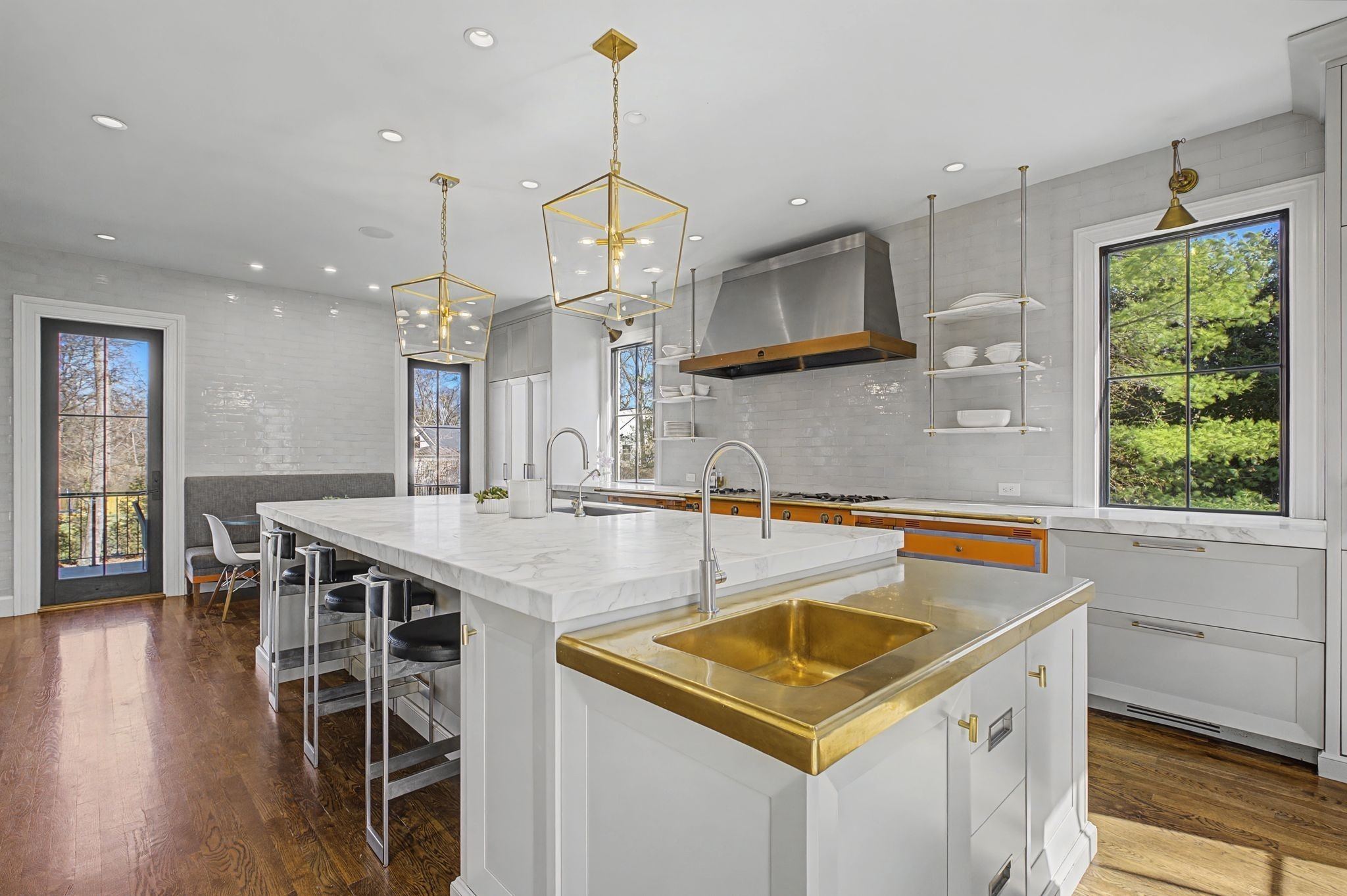 White kitchen with a large island, a range hood and pendant lights at 4304 Warner Place in Belle Meade Nashville