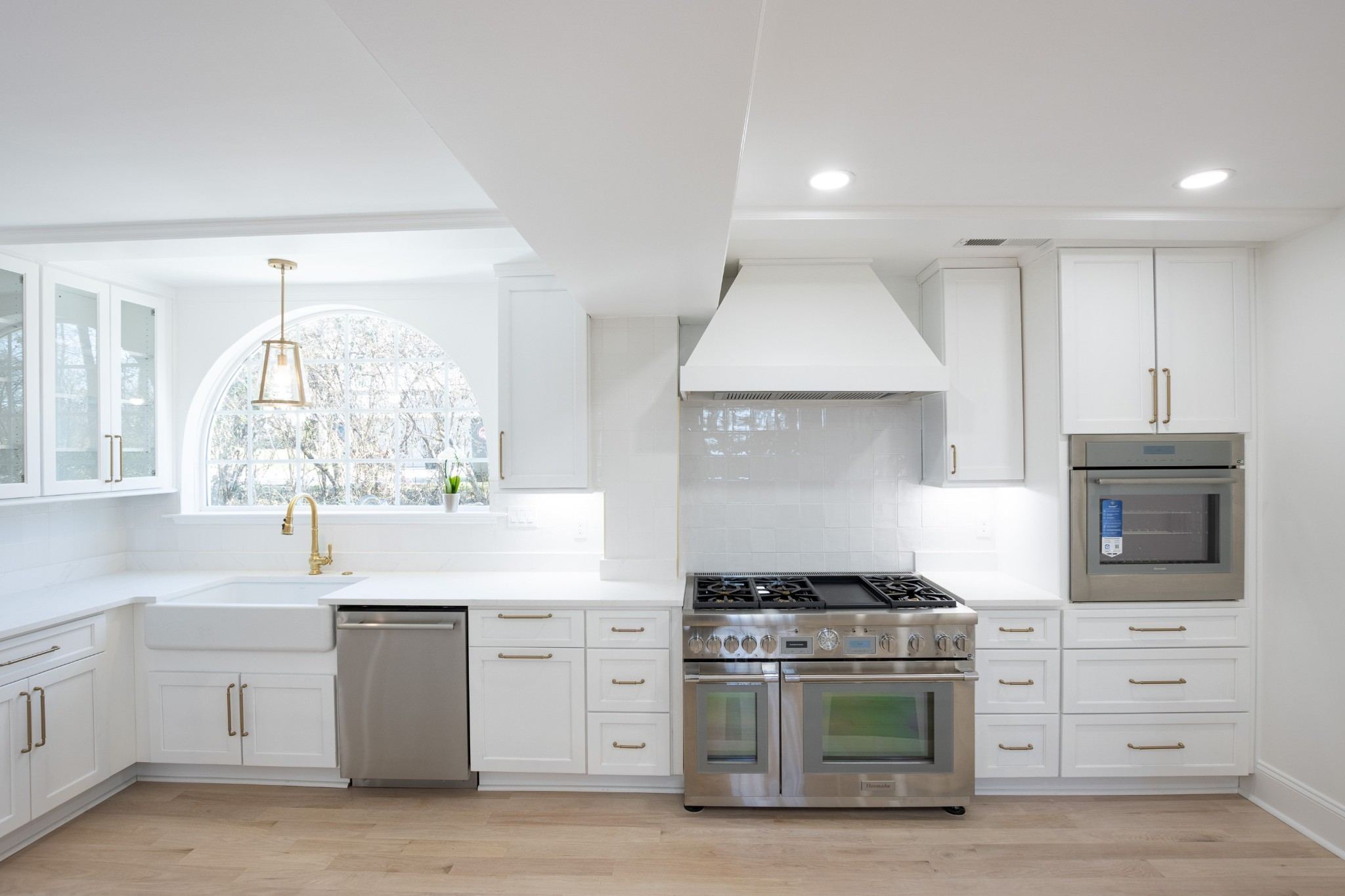 White kitchen with a large range, a hood and a big island at 4401 Iroquois Avenue in Belle Meade Nashville