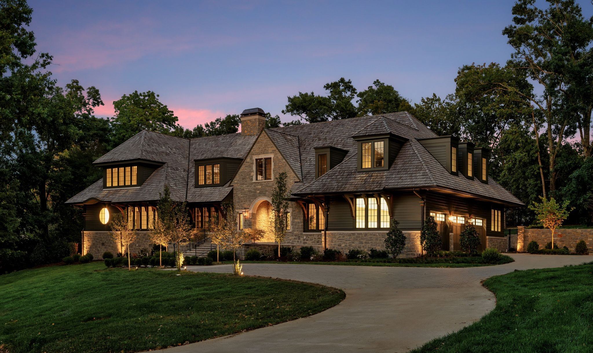 Front of 606 Westview Avenue at dusk with lights on inside and a curving driveway in Belle Meade Nashville